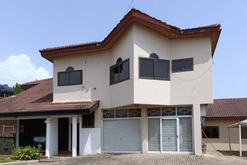 Front view of a luxurious 5-bedroom East Airport house rental in Accra with a landscaped garden and paved driveway