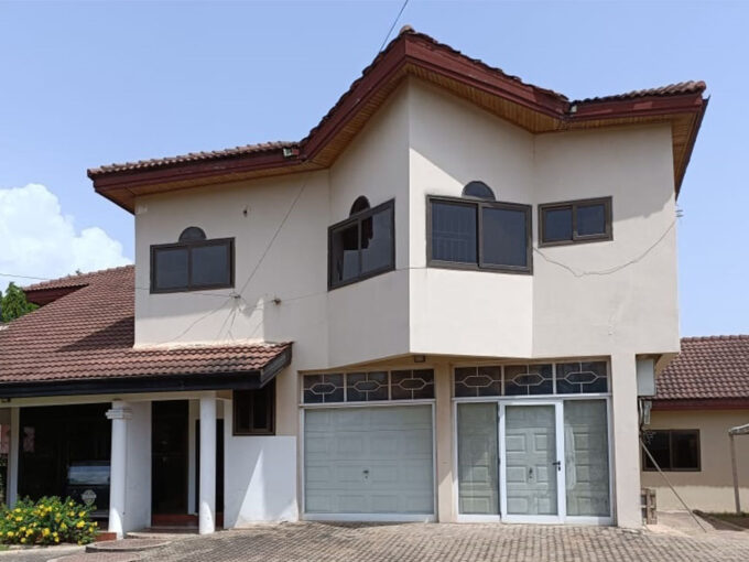 Front view of a luxurious 5-bedroom East Airport house rental in Accra with a landscaped garden and paved driveway